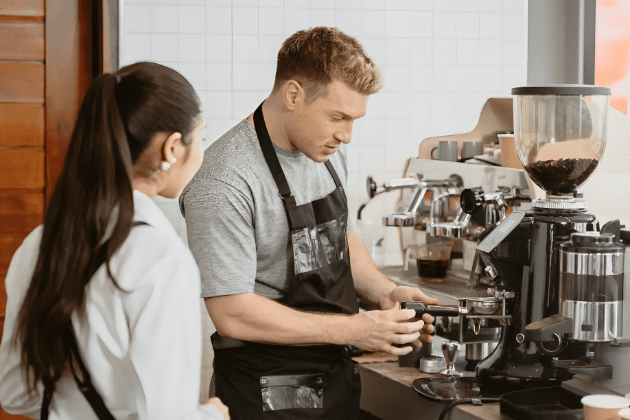 Barista preparing coffee with espresso machine.