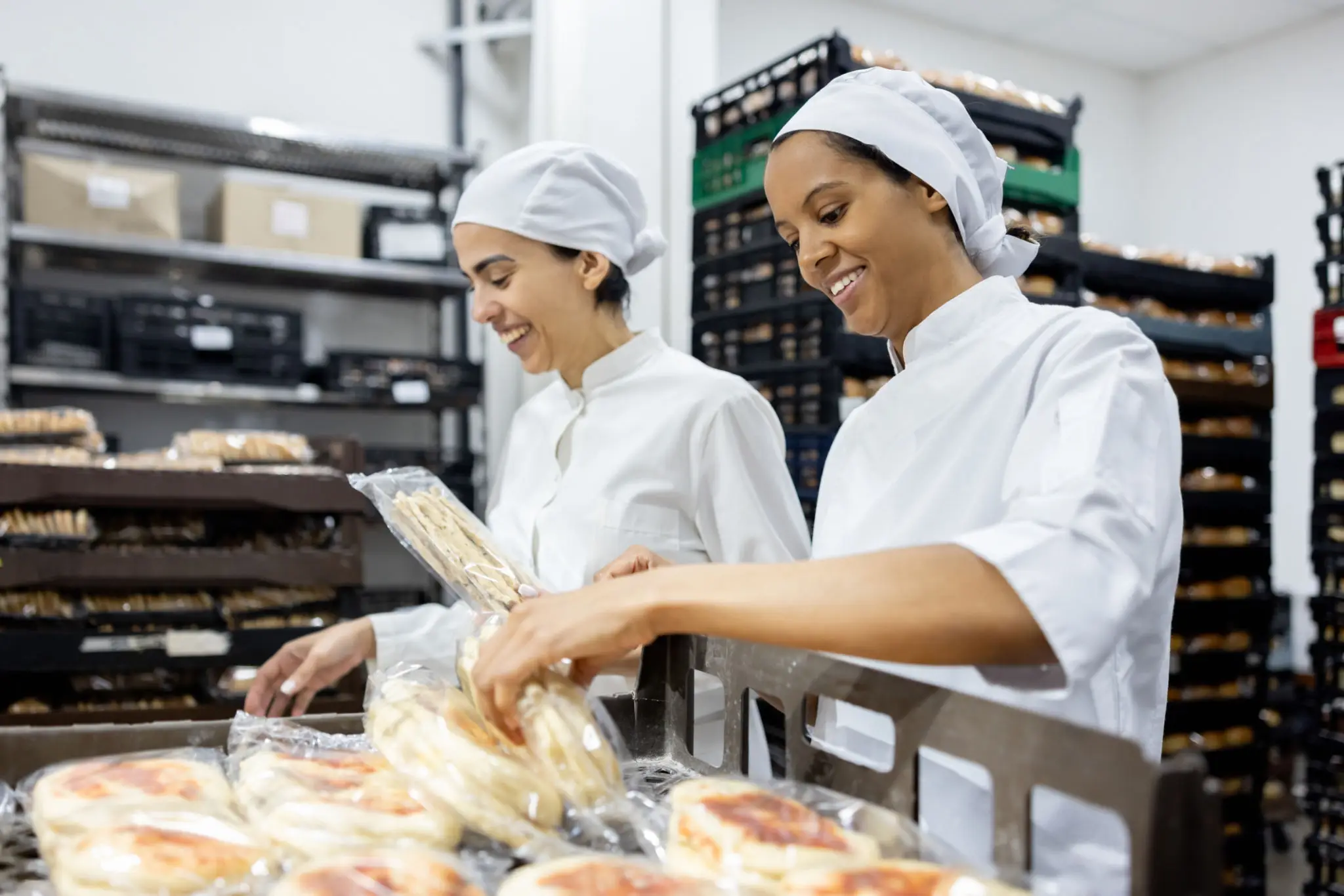 Bakers packaging bread in a bakery.