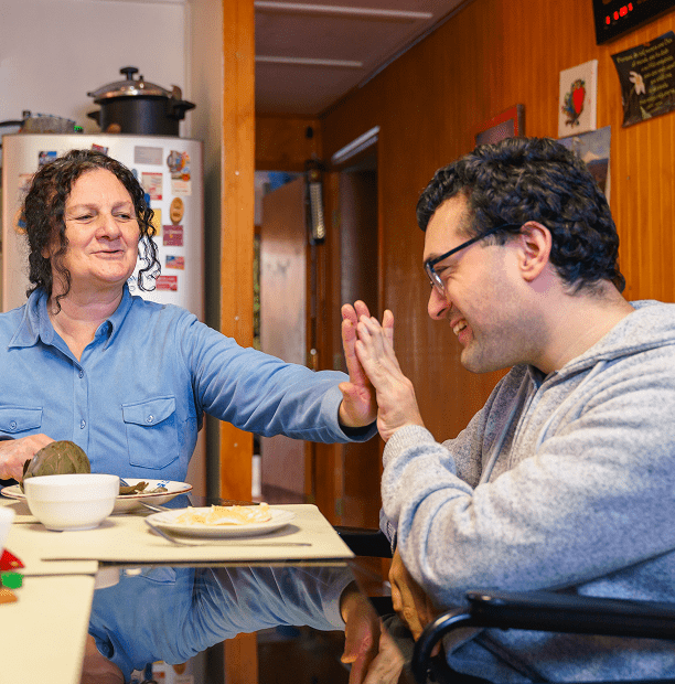 Two people smiling at each other, dining.